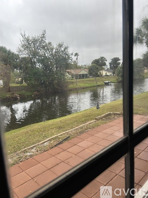 A view of a pond through a window with a tiled floor.