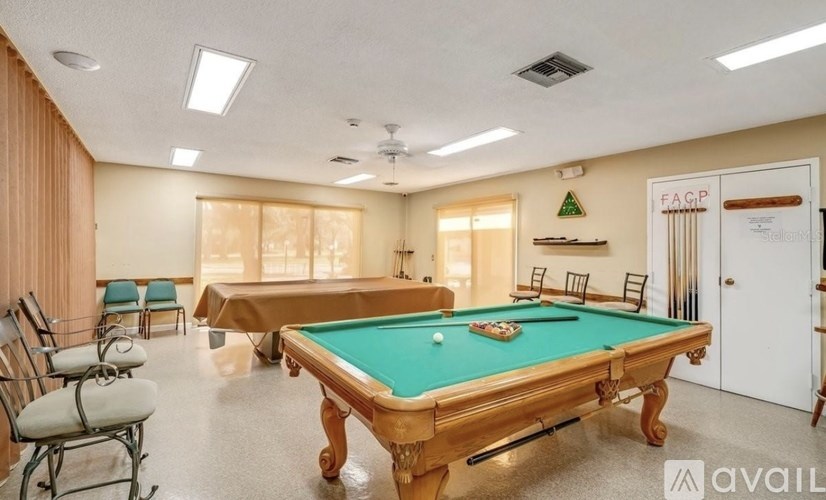 A pool table in a room with chairs and a sign that says "FAQ".