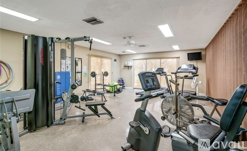 A well-equipped gym with various exercise machines and a mirror.