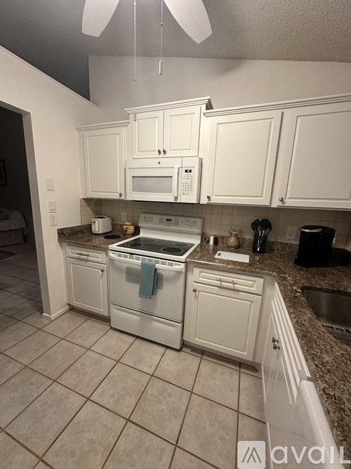 A kitchen with white cabinets and appliances.