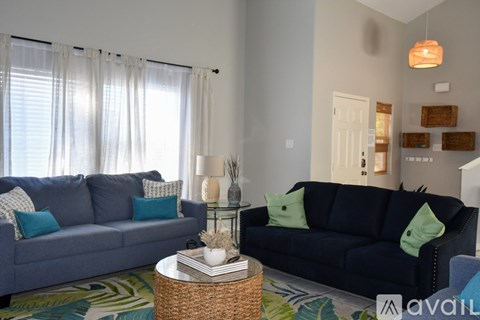 A living room with a blue couch and a grey couch.