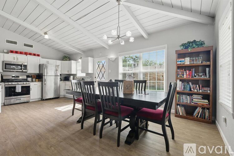 A kitchen with a dining table and chairs.