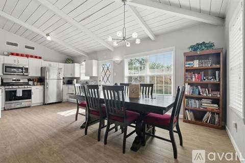 A kitchen with a dining table and chairs.