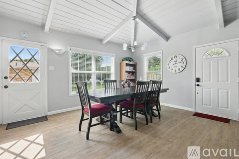 A dining room with a table set for four and a ceiling fan.