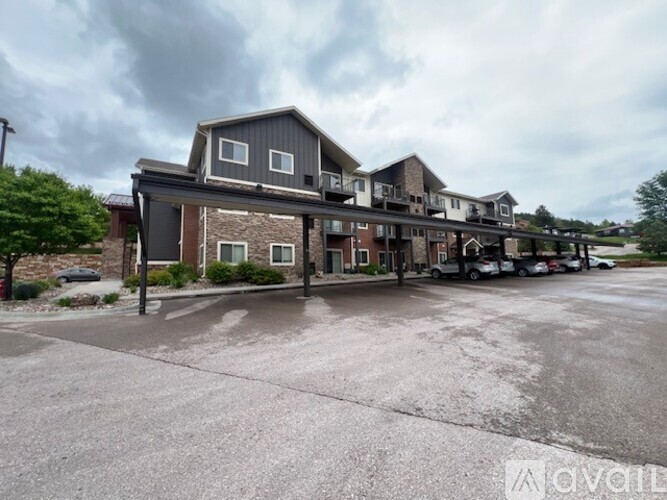 A row of houses with a parking lot in front.