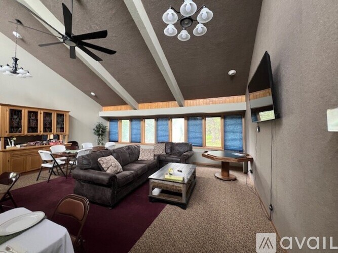 A living room with a grey couch, a coffee table, and a ceiling fan.