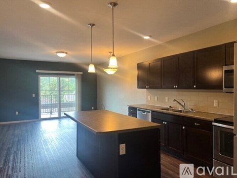 A kitchen with dark wood cabinets and a large island.