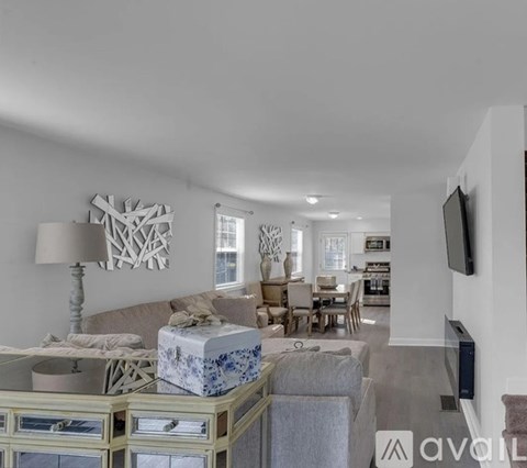 A living room with a grey couch and a white lamp.