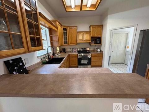 A kitchen with wooden cabinets and a black refrigerator.