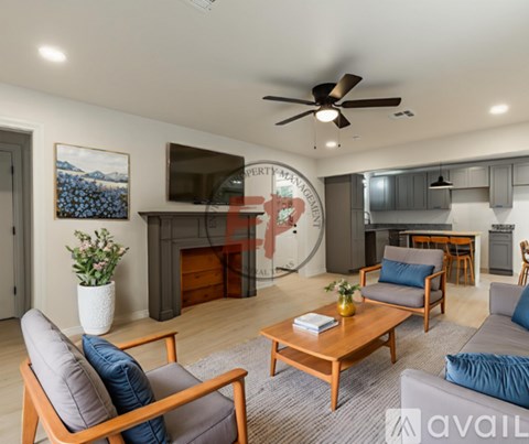 A living room with a fireplace and a painting of a mountain scene on the wall.