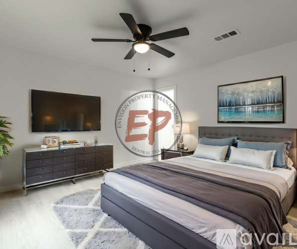 A bedroom with a bed, dresser, and ceiling fan.