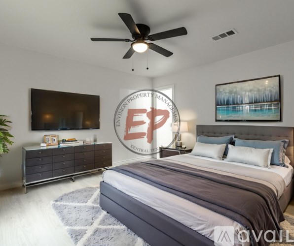 A bedroom with a bed, dresser, and ceiling fan.
