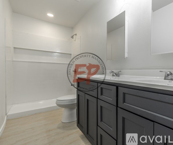 A bathroom with a toilet, sink, and mirror.