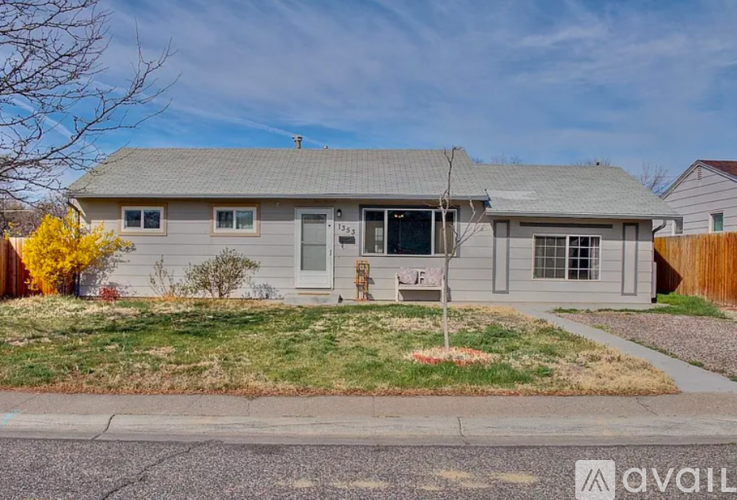 A house with a grey roof and a white door is for sale.
