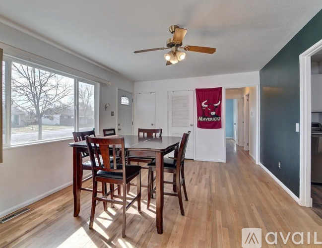 A dining room with a table and chairs and a ceiling fan.