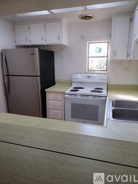 A kitchen with a stove, refrigerator, and microwave.