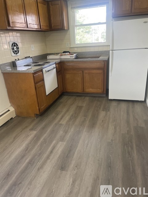 A kitchen with wooden cabinets and a white refrigerator.