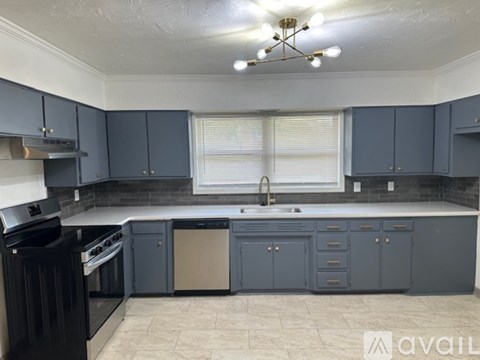 A kitchen with dark blue cabinets and a black dishwasher.