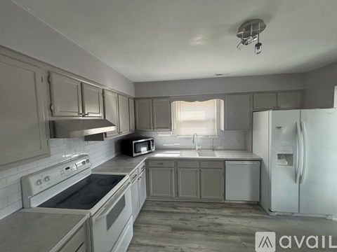 A kitchen with a white fridge, stove, and oven.