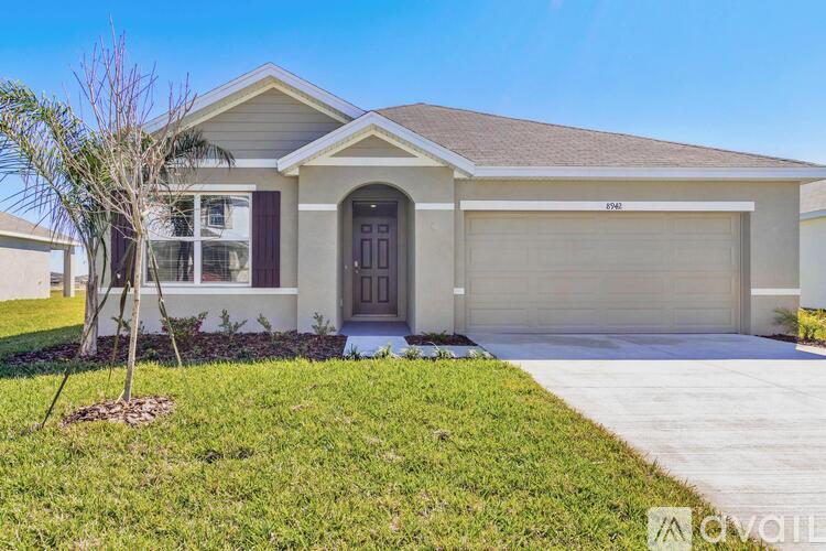 A house with a brown roof and a garage door is for sale.