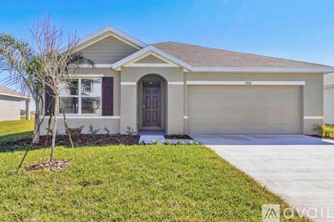 A house with a brown roof and a garage door is for sale.