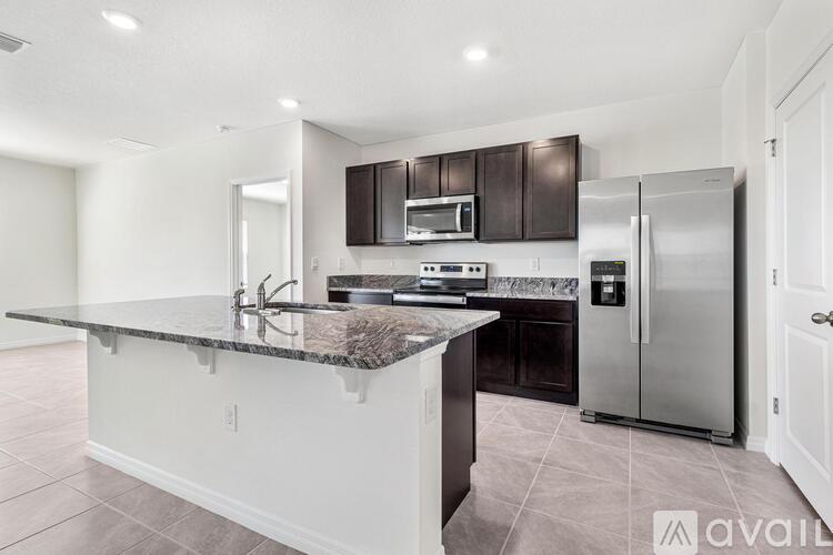 A kitchen with a granite countertop and stainless steel appliances.