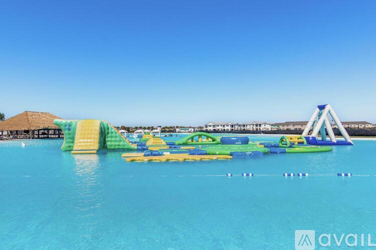 A large inflatable water park structure is floating in a blue pool.