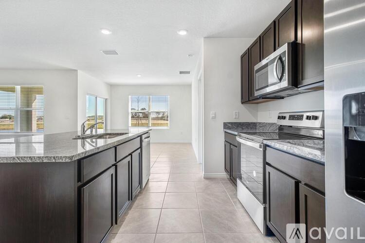 A modern kitchen with dark wood cabinets and stainless steel appliances.
