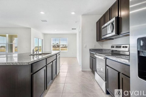 A modern kitchen with dark wood cabinets and stainless steel appliances.