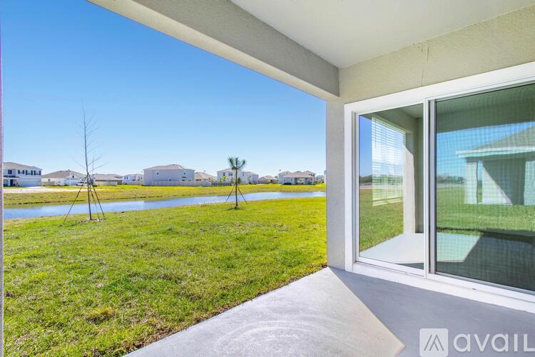 A balcony with a view of a grassy area and buildings.