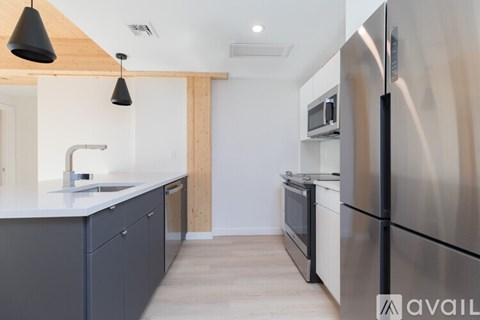 A kitchen with a stainless steel refrigerator and a white countertop.