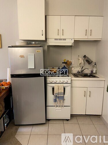 A kitchen with a fridge, stove and cabinets.