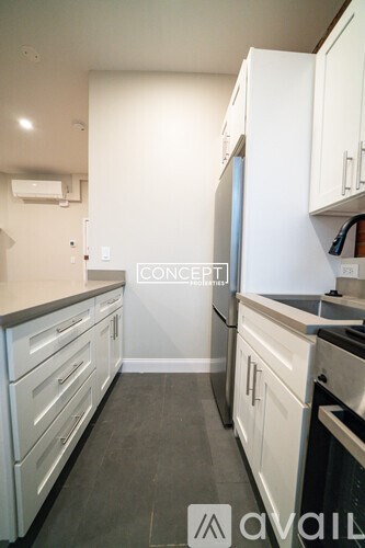 A kitchen with white cabinets and a black stove top oven.