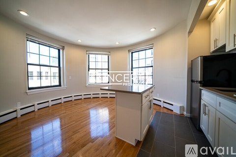 A kitchen with wooden floors and white cabinets is available for rent.
