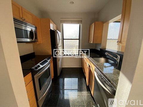 A kitchen with black countertops and stainless steel appliances.