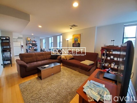 A living room with a brown couch and a coffee table.