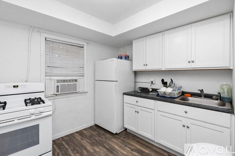 A kitchen with white cabinets and a black countertop.