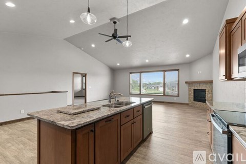 A modern kitchen with a large island and a fireplace.