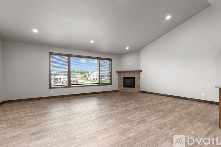 A spacious living room with a fireplace and large windows.