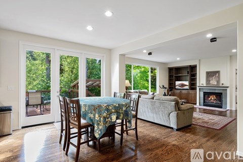 A living room with a fireplace and a dining table with chairs.
