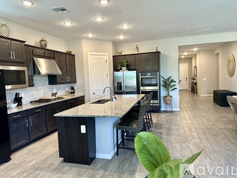 A modern kitchen with dark wood cabinets and a granite countertop.