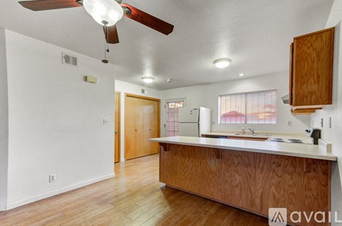 A kitchen with wooden cabinets and a ceiling fan.