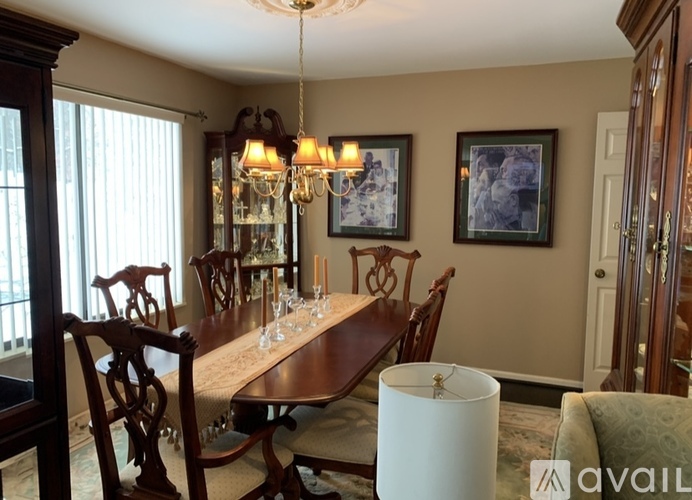 A dining room with a wooden table and chairs.