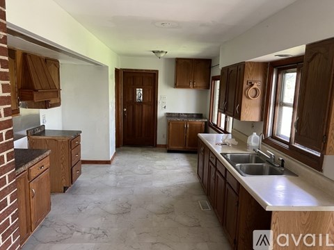A kitchen with wooden cabinets and a marble countertop.