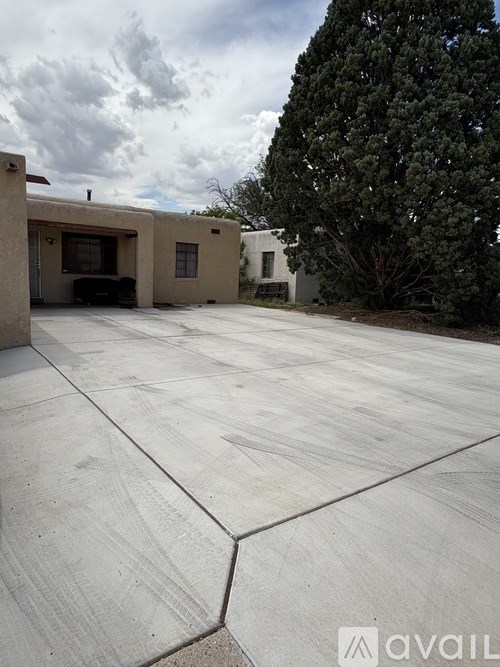 A concrete driveway leads to a house with a garage.