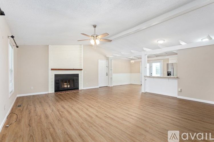 A living room with a fireplace and a ceiling fan.