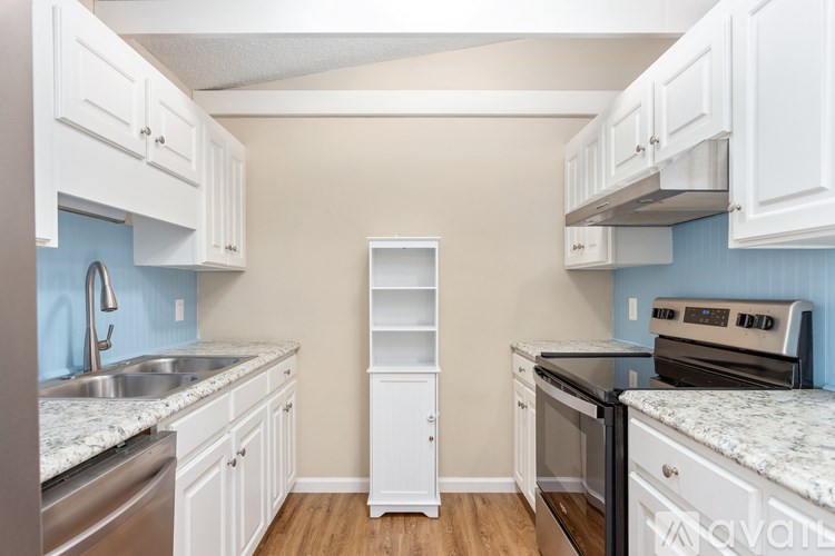 A kitchen with white cabinets and a blue backsplash.