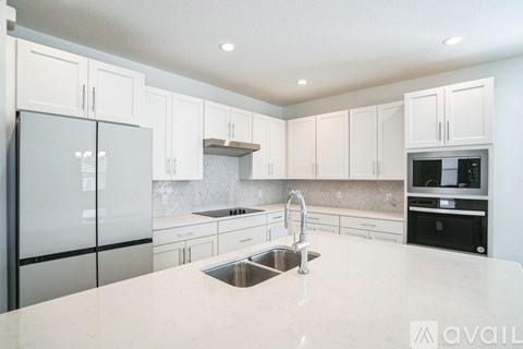 A kitchen with white cabinets and a marble countertop.