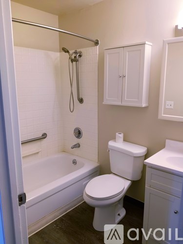 A white toilet sits next to a bathtub in a bathroom.