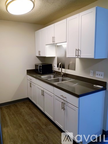 A kitchen with white cabinets and a blue island.